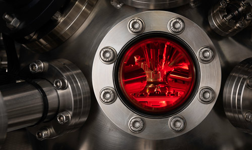 Close-up of equipment with red light on the inside of silver metal