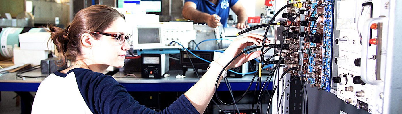 Woman plugging wires into equipment